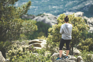 Ein Frau blickt während einer Wanderung ins Tal